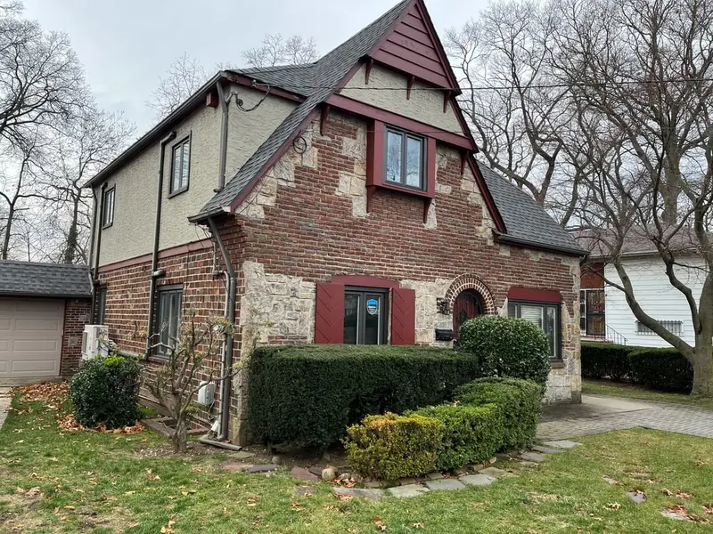 Brick and stone Tudor with a steep front gable, Hempstead, NY